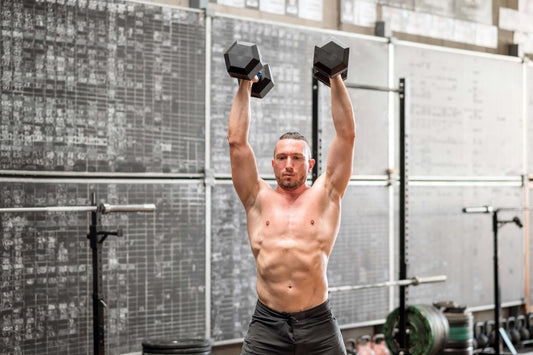 Athlete does a devil's press with dumbbells.