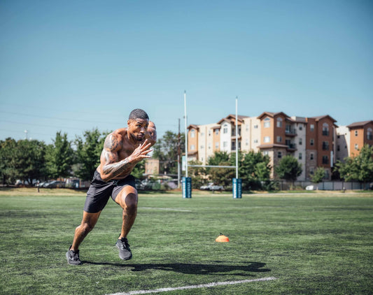 Athlete sprints on a field.