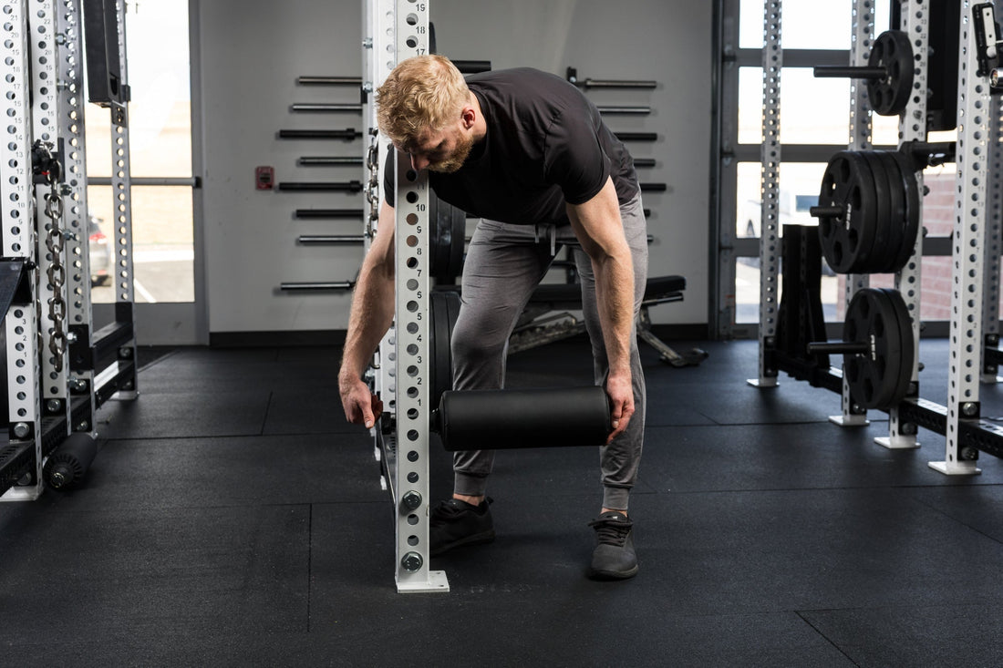Athlete attaches leg roller to upright.
