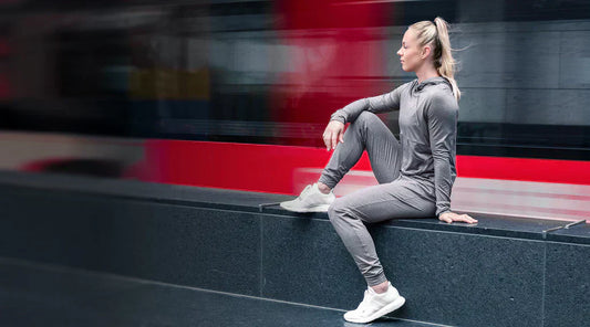 A woman sits outside in REP apparel.