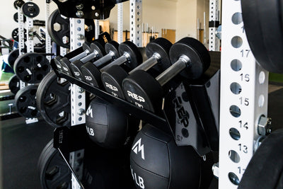 REP Fitness 41in Dumbbell & Kettlebell Shelf installed on a 5000 Series rack with dumbbells on it