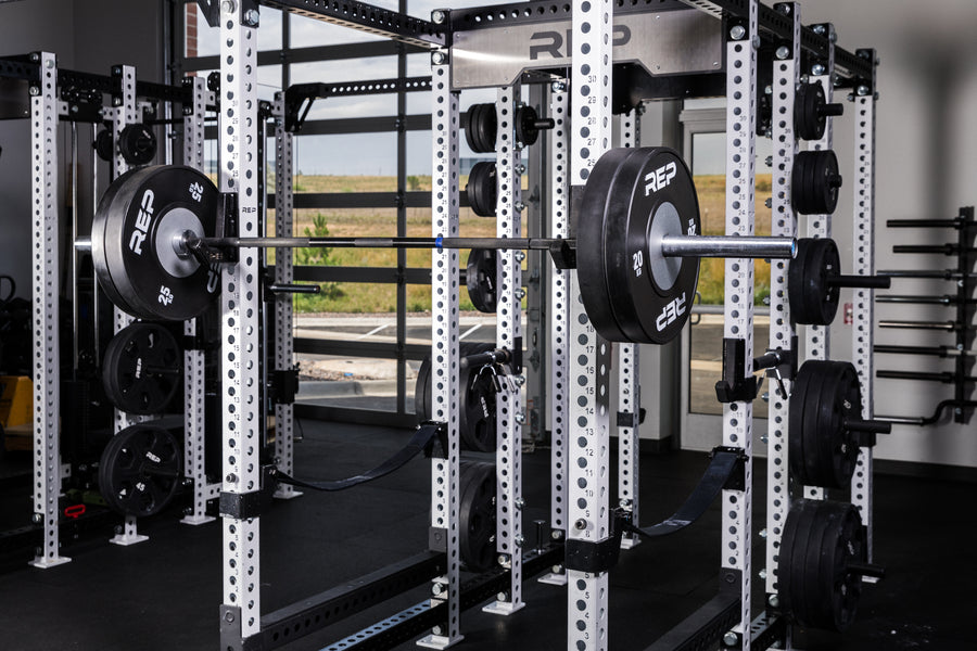 Black Competition Bumper Plates (KG) loaded onto a barbell racked on a PR-5000 rack