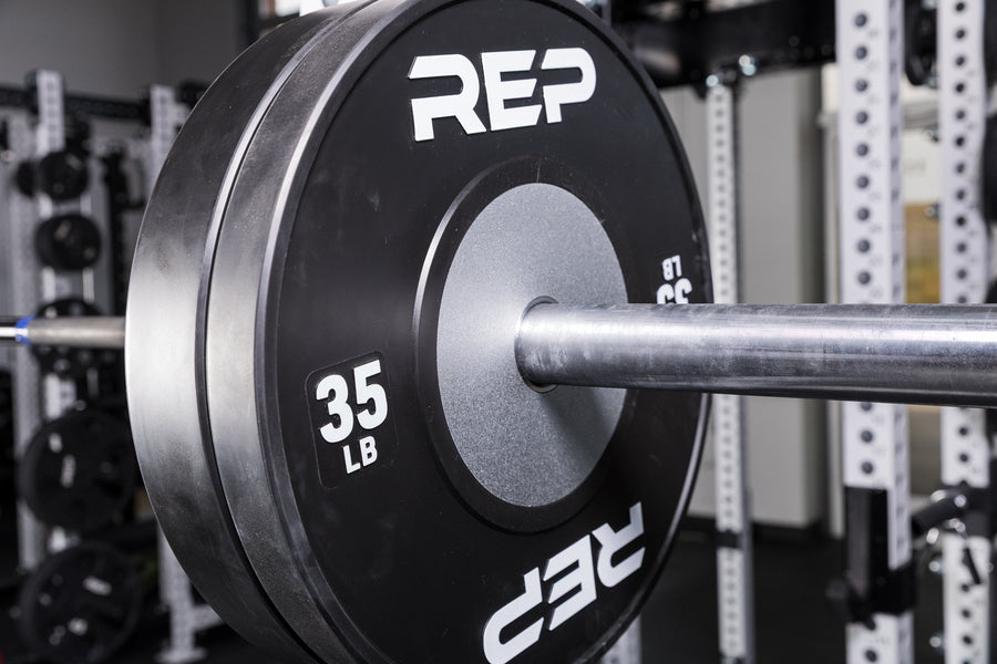 Black Competition Bumper Plates (LB) loaded onto a barbell