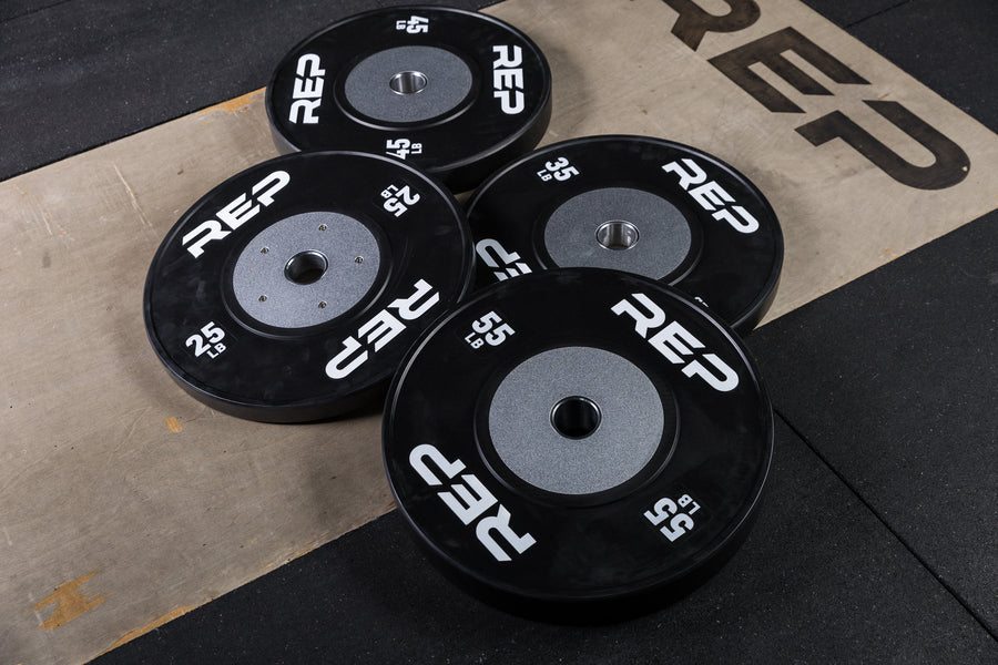 Black Competition Bumper Plates (LB) laying on a lifting platform