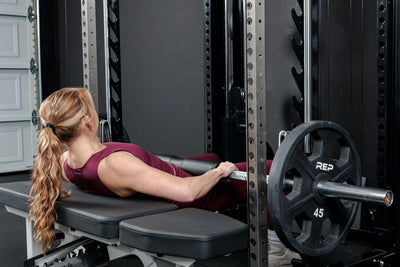 Athlete using the REP Fitness Altitude™ Power Rack Smith Machine Attachment for hip thrusters