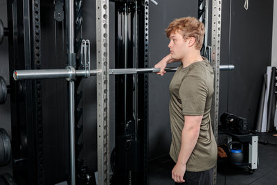 Athlete moving the REP Fitness Altitude™ Power Rack Smith Machine barbell with one arm
