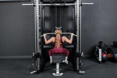 Athlete doing lat pulldowns while using the REP Fitness Altitude™ Leg Roller as a leg restraint