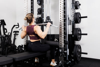 Person using the Ares™ 2.0 for lat pulldowns on the Summit™ All-In-One Ares™ 2.0 configuration in a gym setting.