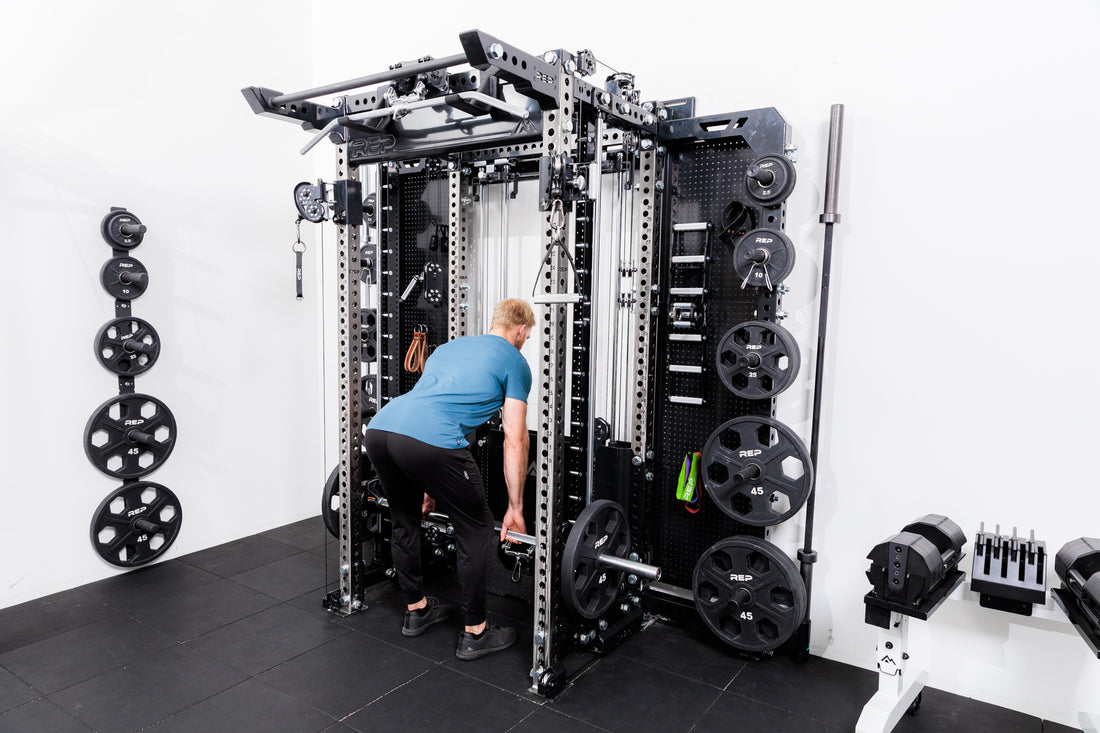 Person using the Smith Machine Rack Attachment for RDLs on the Summit™ All-In-One Ares™ 2.0 Wall-Mounted configuration in a gym setting.