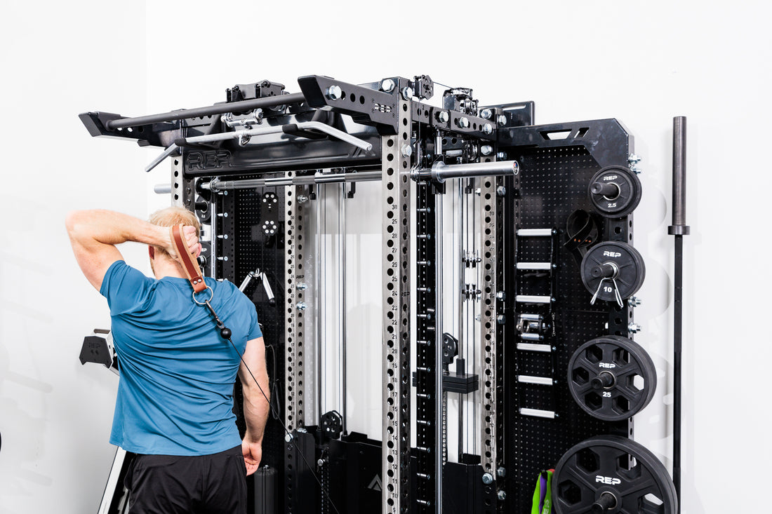 Person using the Ares™ 2.0 for cable machine exercises on the Summit™ All-In-One Ares™ 2.0 Wall-Mounted configuration in a gym setting.