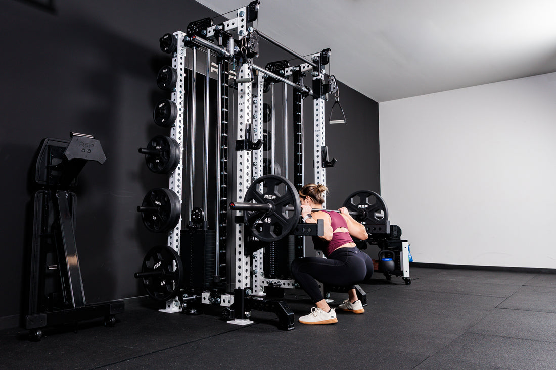 Women performing squats off the front of the Summit™ All-In-One Trainer with Athena™ in a home gym setting.
