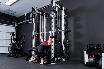 Women using the Smith Machine Rack Attachment for incline bench on the Summit™ All-In-One Trainer with Athena™in a home gym setting.