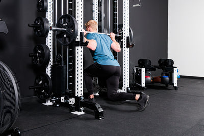 Person performing lunges with the Smith Machine Rack Attachment on the Summit™ All-In-One Athena™ .