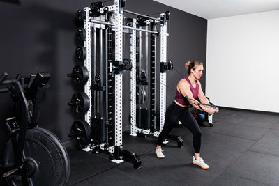 Women performing cable machine exercises on the Summit™ All-In-One Trainer with Athena™in a home gym setting.
