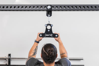 Athlete using the REP Fitness Shackle attached to a PR-5000 crossmember with a REP x Kleva Built close-grip attachment