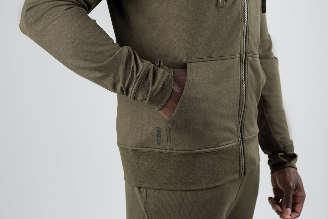 The REP Fitness Men's Attis Jacket in Heather Olive front, hand in pocket detail