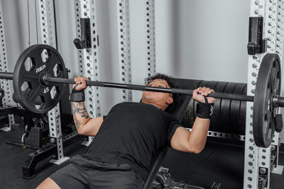 Front shot of an athlete's wrists being supported by the REP Wrist Wraps while pressing a loaded barbell