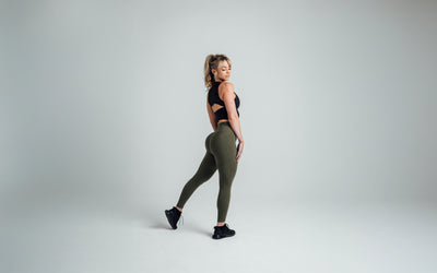 Side shot of an athlete striking a pose while wearing the REP Rhea Tank in Black