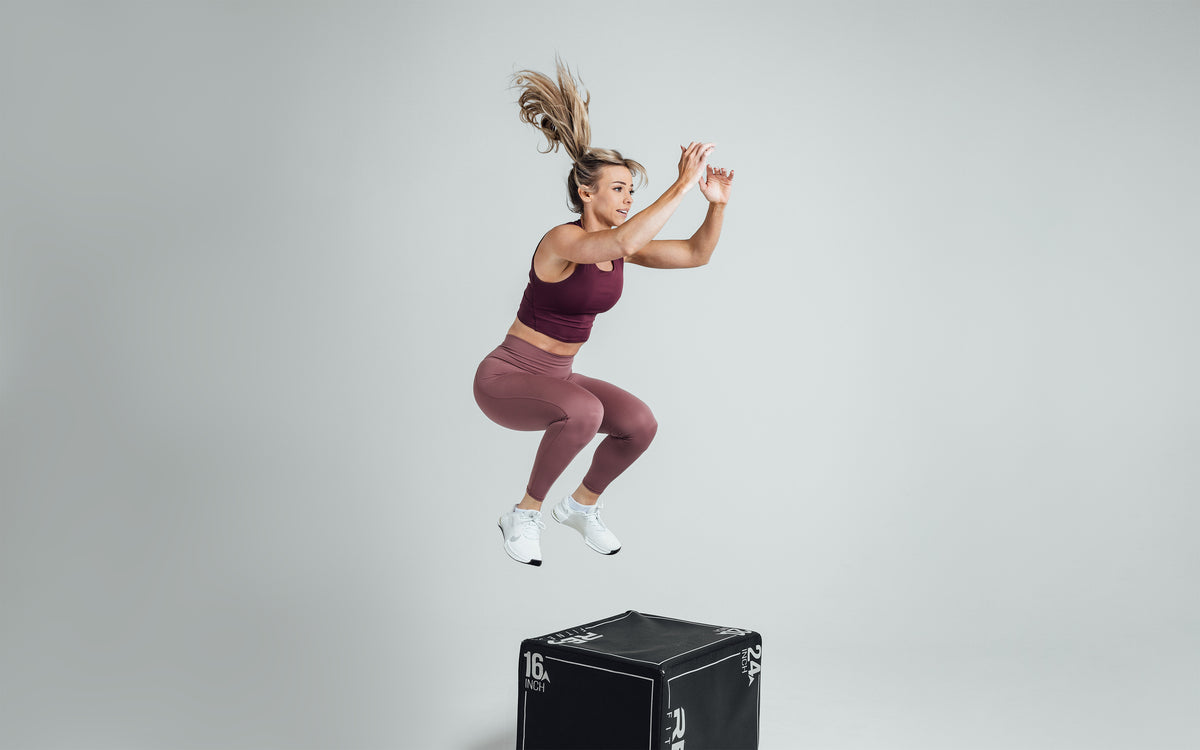 Athlete performing a box jump while wearing the REP Rhea Tank in Wine