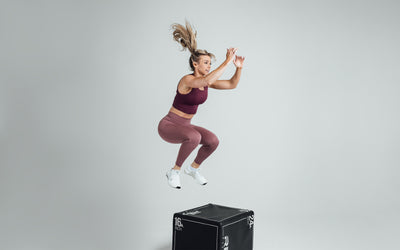 Athlete performing a box jump while wearing the REP Rhea Tank in Wine