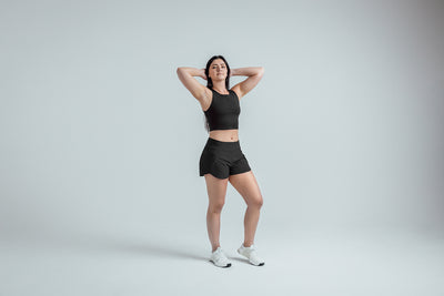 The REP Fitness Women's Artemis Shorts in Black front, hands behind head