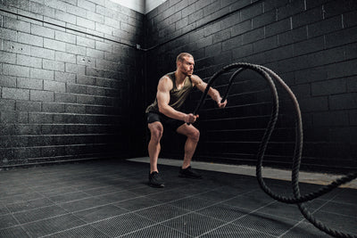 The REP Fitness Men's Sigmatech Tank Top in Heather Olive front, with battle ropes