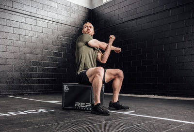Athlete stretching in a Heather Olive Sigmatech Shirt. Also available in Heather Navy, Heather Black.