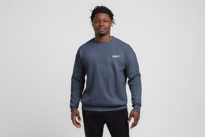 The REP Fitness Unisex REP® Crewneck Sweatshirt in Heather Navy/White front, on model