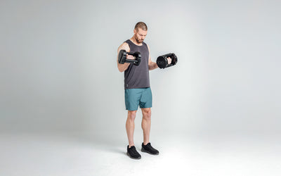 The REP Fitness Men's Motus Shorts in Slate front, dumbbell curl