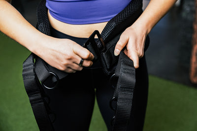 Showing person putting on belt squat belt and the g-hook mechanism.