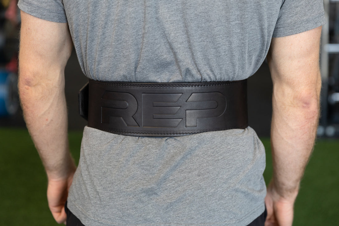 Athlete putting on the black REP Premium Leather Lifting Belt.