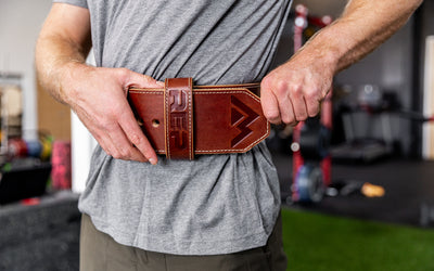Athlete putting on the brown REP Premium Leather Lifting Belt.