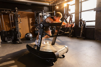 Athlete pushing in sled mode on the REP Fitness Strive Curved Treadmill