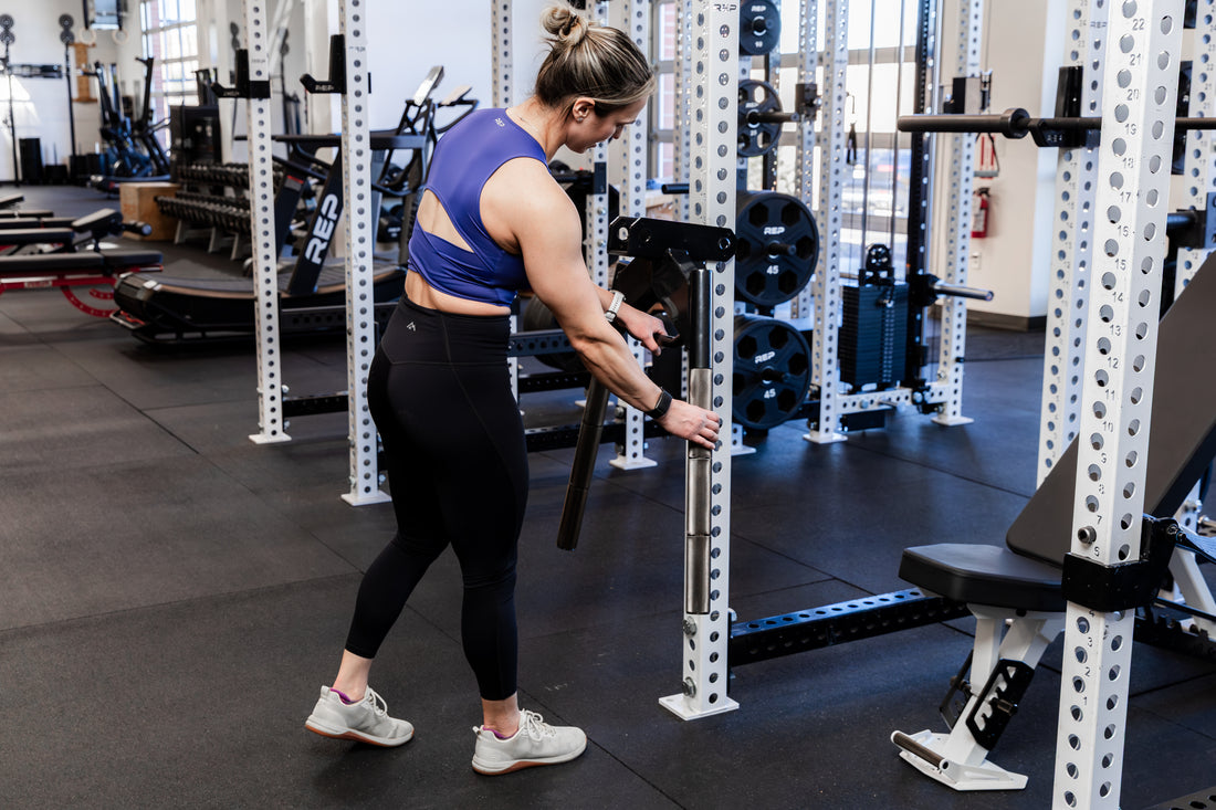 Athlete storing the REP Fitness Dip Attachment 2.0 on a 5000 series power rack upright
