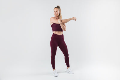 The REP Fitness Women's Eos Legging in Wine front, stretching