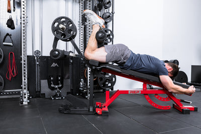 Athlete doing hamstring curls on the Leg Extension & Leg Curl Bench Attachment