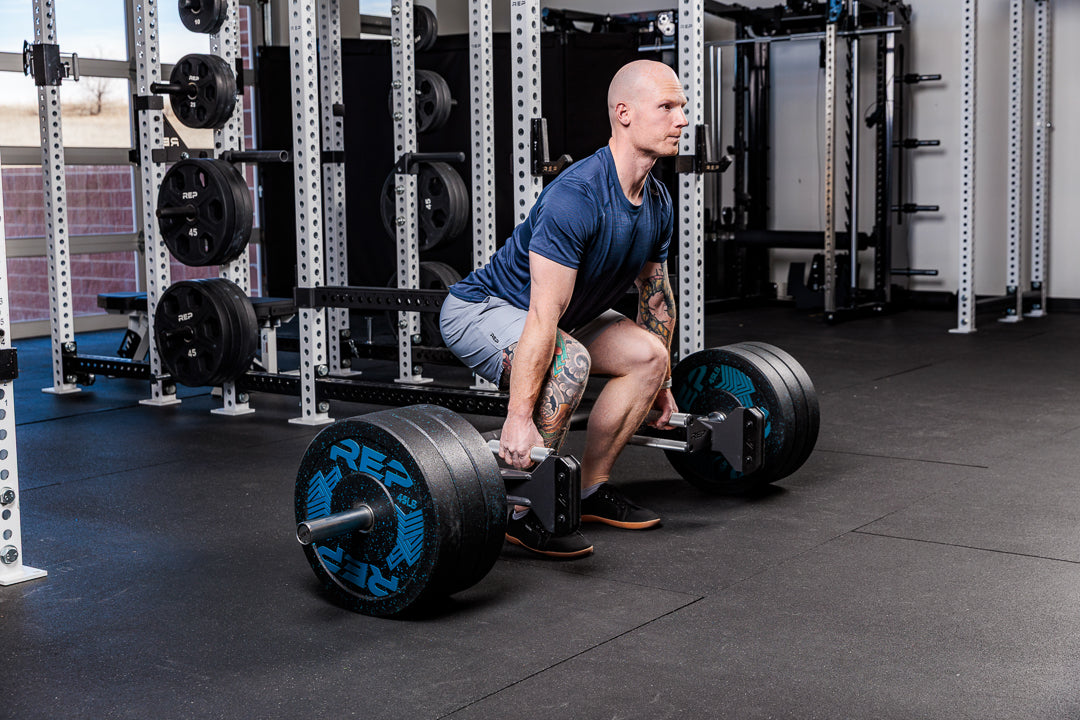 Man performing deadlift with the Fixed Open trap bar in a gym setting