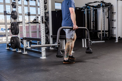 Man carrying the Fixed Open trap bar in a gym setting