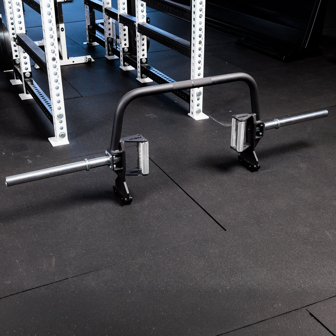 Fixed Open Trap Bar (Rackable)- showing the entire barbell  standing on its built in jacks on the gym floor