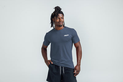 The REP Fitness Men's USA Tri-Blend Crew T-Shirt in Heather Navy/White front, hands in pockets