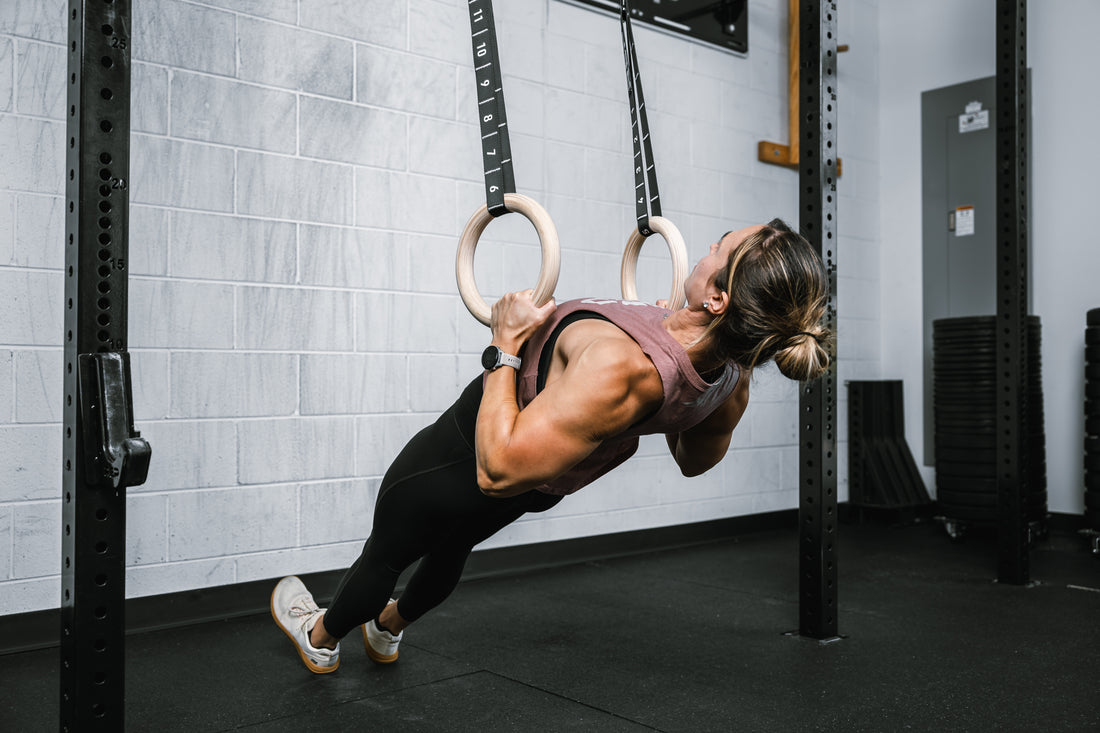 Athlete doing rows on REP Competition Gymnastic Straps and Wood Rings from a REP Wall-mounted Rig