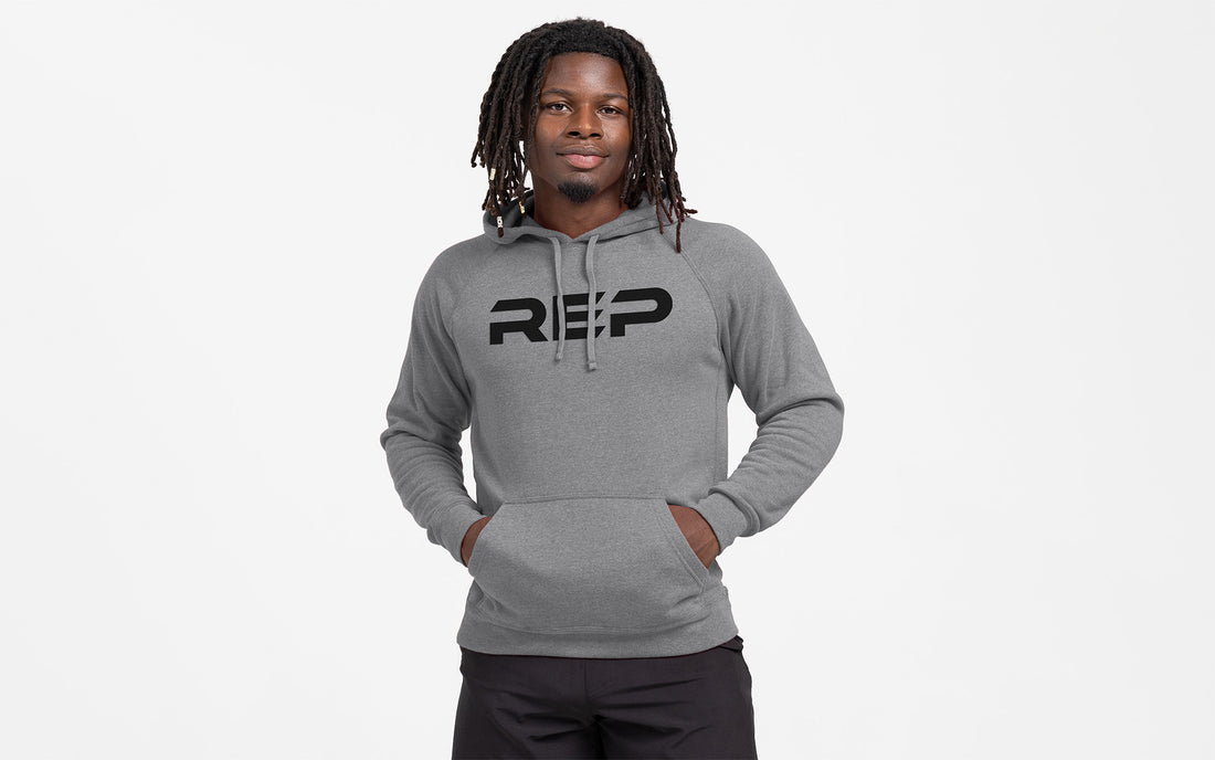 The REP Fitness Unisex Daily Driver 2.0 Pull Over Hoodie in Heather Gunmetal/Black front, hands in pockets