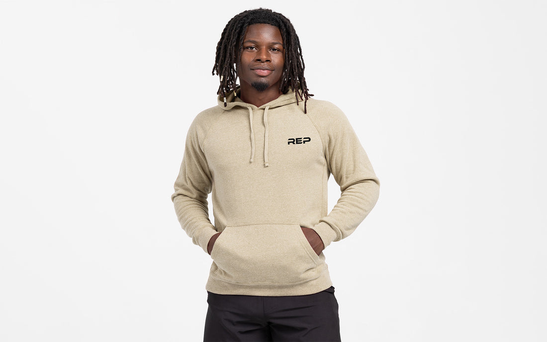 The REP Fitness Unisex USA Pull Over Hoodie in Heather Stone/Black front, hood down, hands in pockets