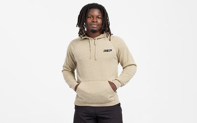 The REP Fitness Unisex USA Pull Over Hoodie in Heather Stone/Black front, hood down, hands in pockets