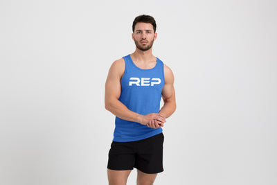 Man wearing the Men's Daily Driver Tri-Blend Tank in Heather Azure/White with shorts