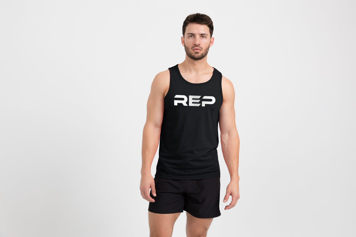 Man wearing the Men's Daily Driver Tri-Blend Tank in Heather Black with shorts