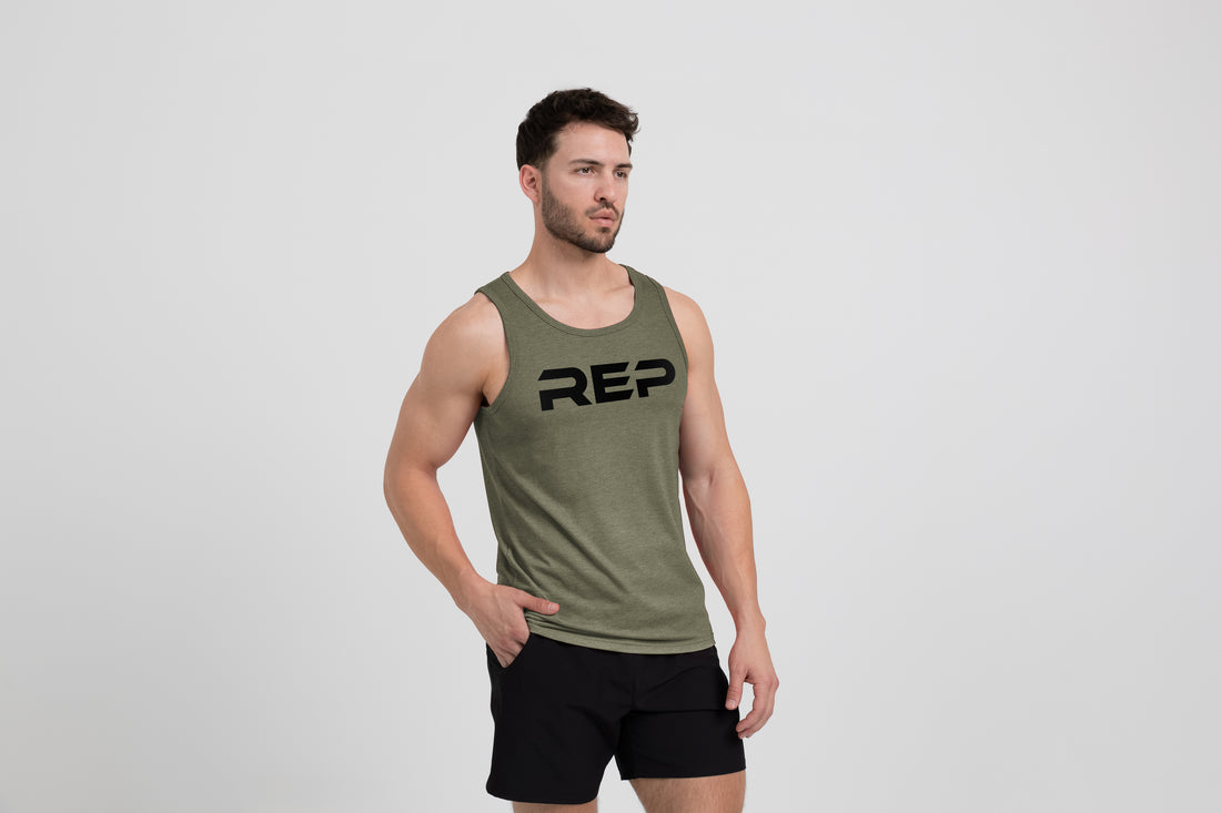 The REP Fitness Men's Daily Driver Tri-Blend Tank in Heather Olive/Black on model