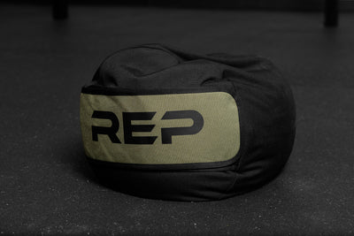 Black and green stone sandbag with 'REP' branding on a dark surface