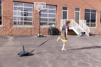 Person using Sled Harness to pull a sled outdoors.