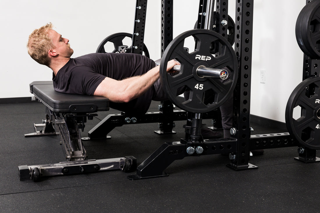 Athlete doing hip thrusters on the front of a rack mounted Smith Machine